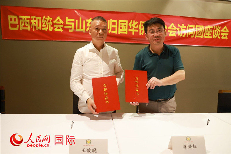 中國僑聯(lián)副主席、山東省僑聯(lián)主席李興鈺（右）與巴西和統(tǒng)會會長王俊曉簽署合作協(xié)議書。人民網(wǎng)記者 陳海琪攝