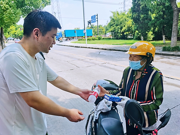 何超為過路的老人送上礦泉水和冷飲。人民網(wǎng)記者 王繼亮攝
