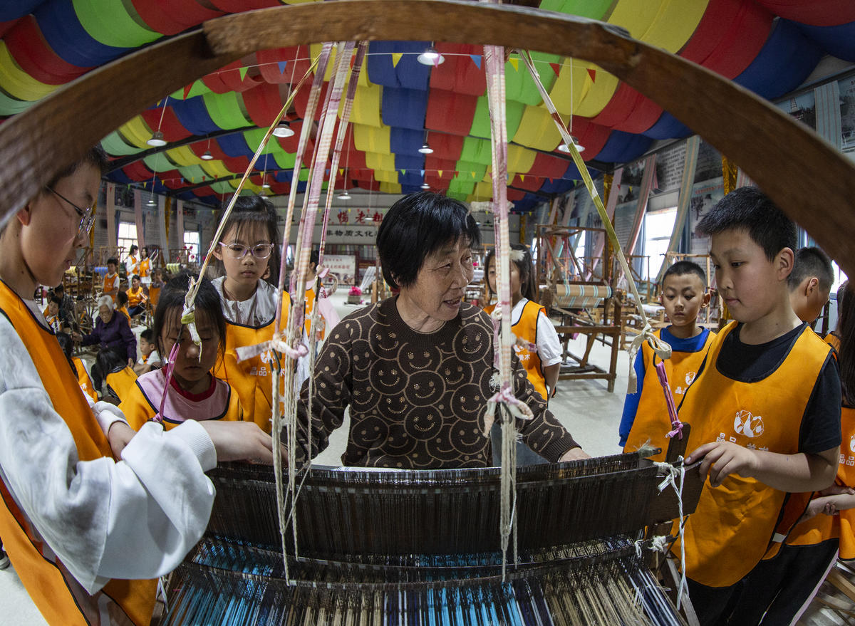 5月1日，在山西省永濟市開張鎮(zhèn)東開張村的惠暢土布文化園，土布制作技師教游客織布技藝。 來源：人民圖片網(wǎng)