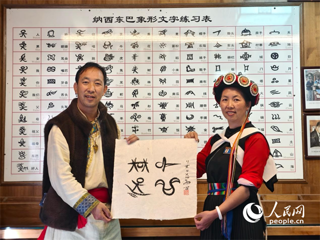 人民網(wǎng)“行進(jìn)中國(guó)”云南調(diào)研采訪團(tuán)走進(jìn)麗江，和閏元現(xiàn)場(chǎng)用東巴文寫(xiě)下“行進(jìn)中國(guó)”。人民網(wǎng)記者 符皓攝
