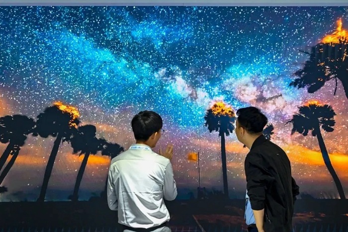 長春光博會希達電子展區(qū)，一位工作人員正在給一位觀眾講解。（長春新區(qū)供圖）