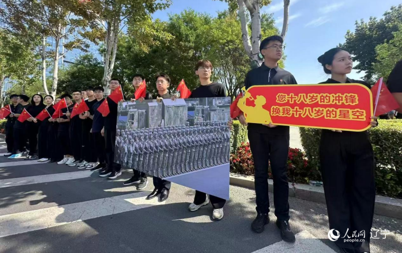 沈陽市人民廣場上，大學(xué)生們手持閱兵的圖片，告慰英烈。人民網(wǎng)記者 周頌雪攝