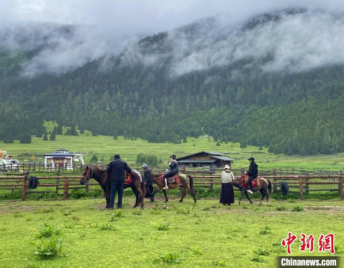 6月10日，游客在魯朗小鎮(zhèn)高山牧場(chǎng)景區(qū)體驗(yàn)騎馬?！∪轿木?攝