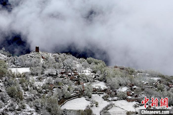 雪后的藏寨和碉樓構(gòu)成美麗的雪景?！〗党鯘衫?攝