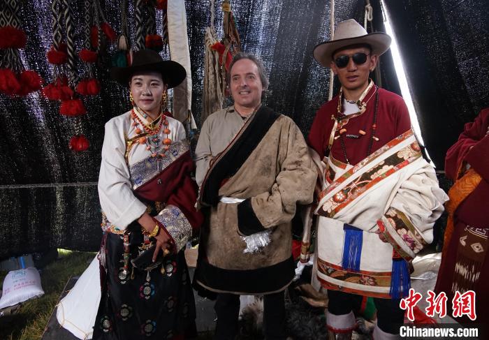 圖為一名外籍?dāng)z影師(中)身穿藏服和藏族民眾合影留念?！●R銘言 攝