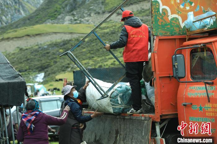圖為工作人員幫助牧民們卸家具?！÷蹇?攝