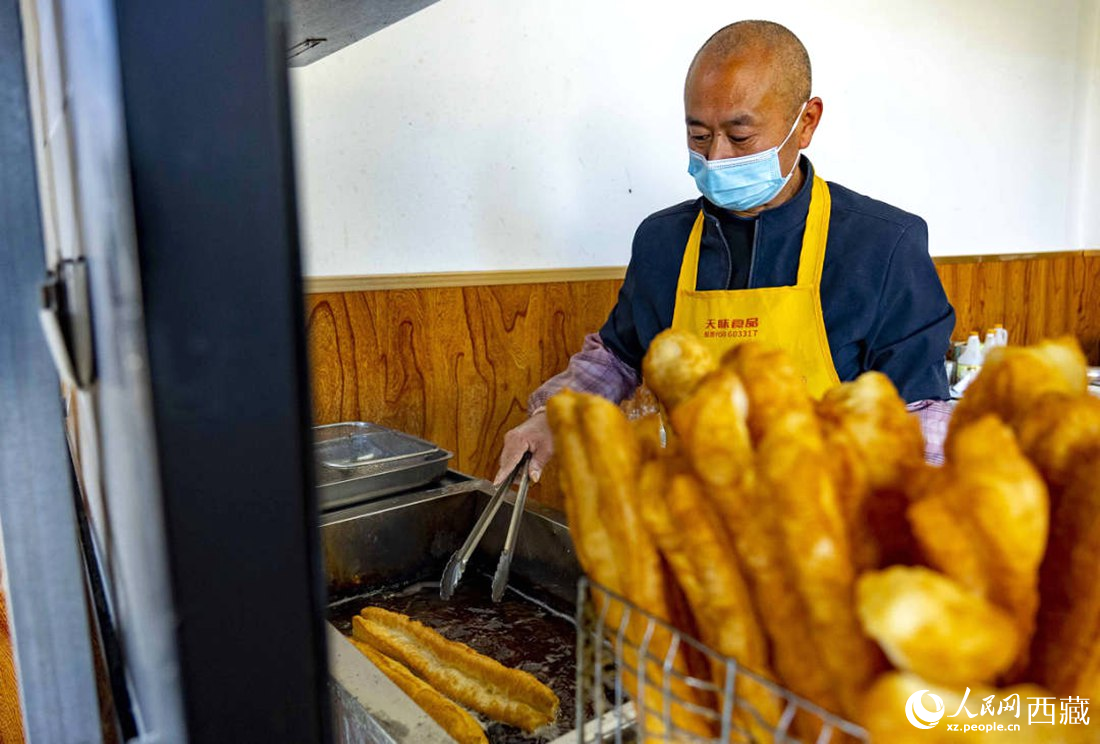 早餐店老板正在炸油條。人民網 次仁羅布攝