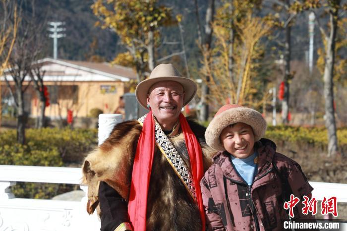 圖為林芝市巴宜區(qū)布久鄉(xiāng)仲果村村民桑杰與孫子一起參加藏歷新年活動?！埩?攝