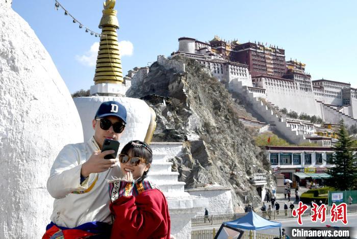 4月17日，游客身著藏式元素服裝在拉薩布達(dá)拉宮觀景臺(tái)拍照留念?！±盍?攝
