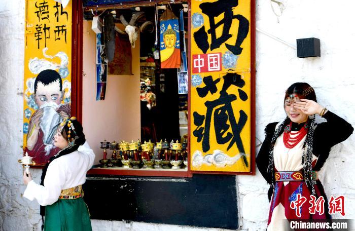 4月17日，游客身著藏式元素服裝在拉薩八廓街拍照留念。　李林 攝