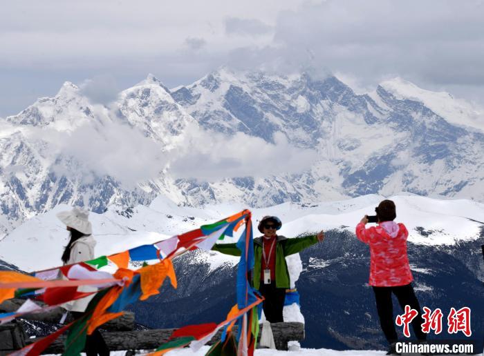 圖為5月14日，西藏林芝色季拉山觀景臺，游客與南迦巴瓦峰合影。　李林 攝