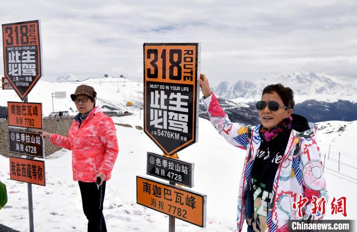圖為5月14日，西藏林芝色季拉山觀景臺，游客與南迦巴瓦峰合影?！±盍?攝