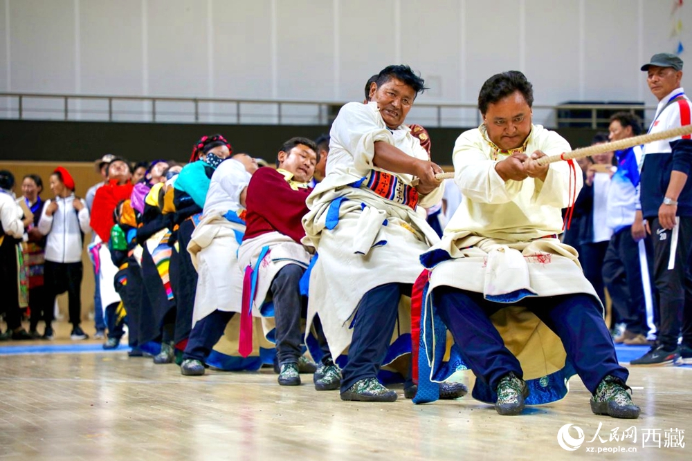 身著民族服裝的農(nóng)牧民選手在拔河比賽現(xiàn)場。