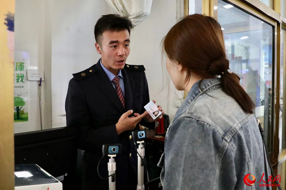 車站工作人員向旅客解答疑問。人民網(wǎng)記者 次仁羅布攝